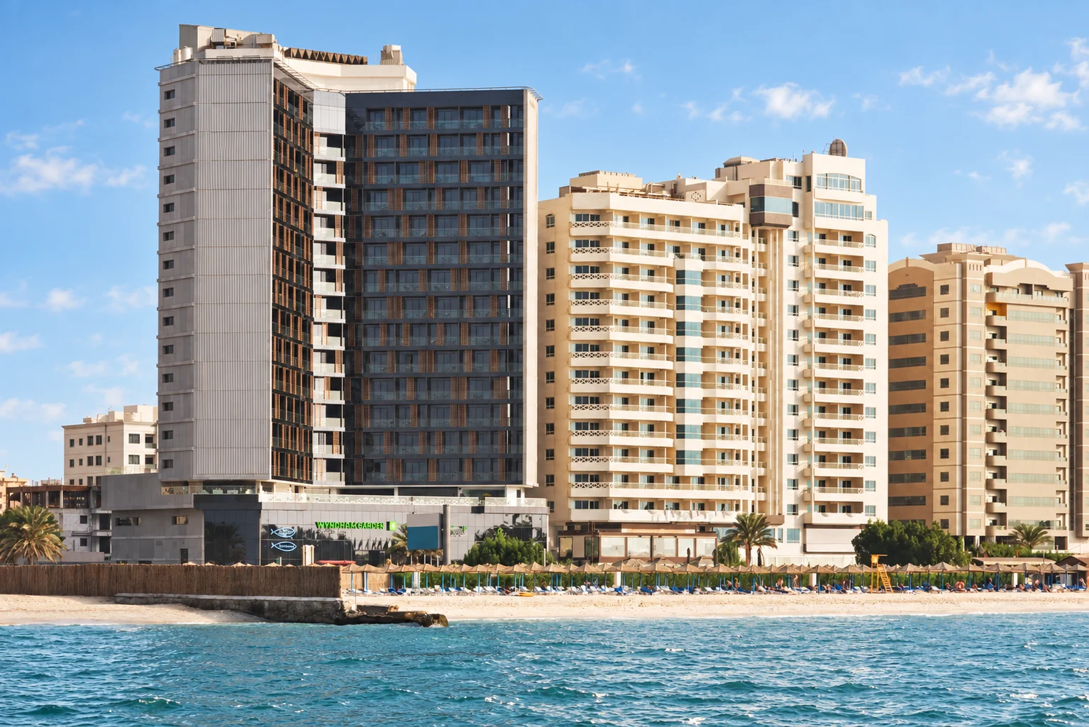 Пляж и городские фасады у Wyndham Garden Ajman Corniche
