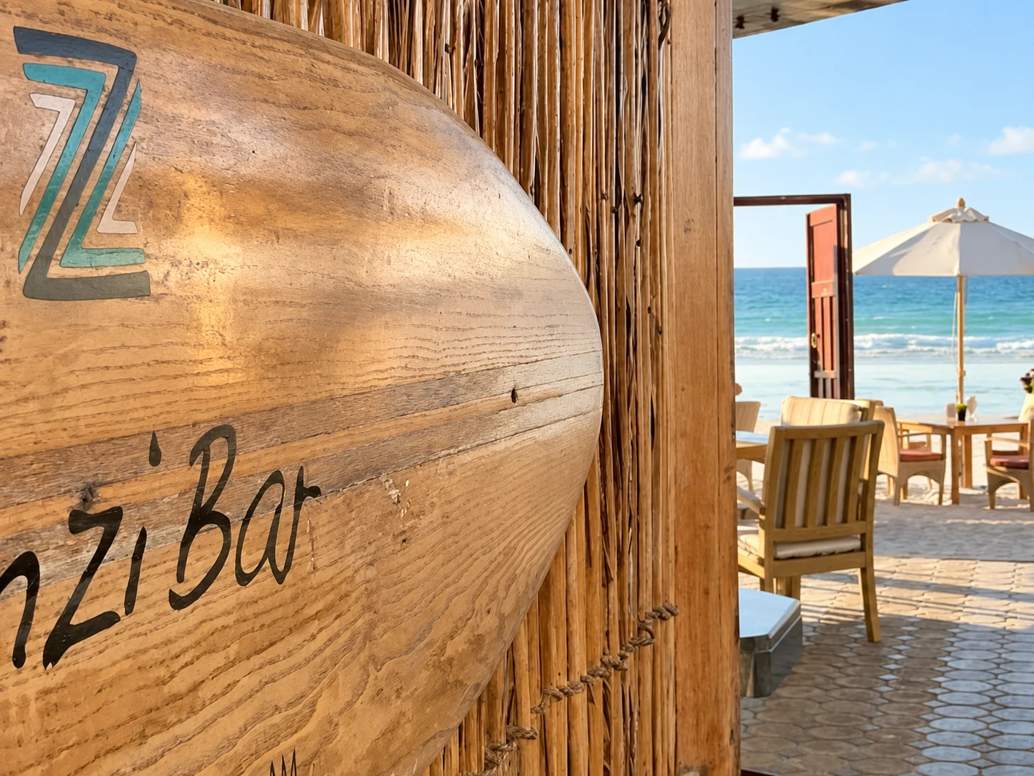 Деревянная вывеска ZanziBar и вид из входа на пляж