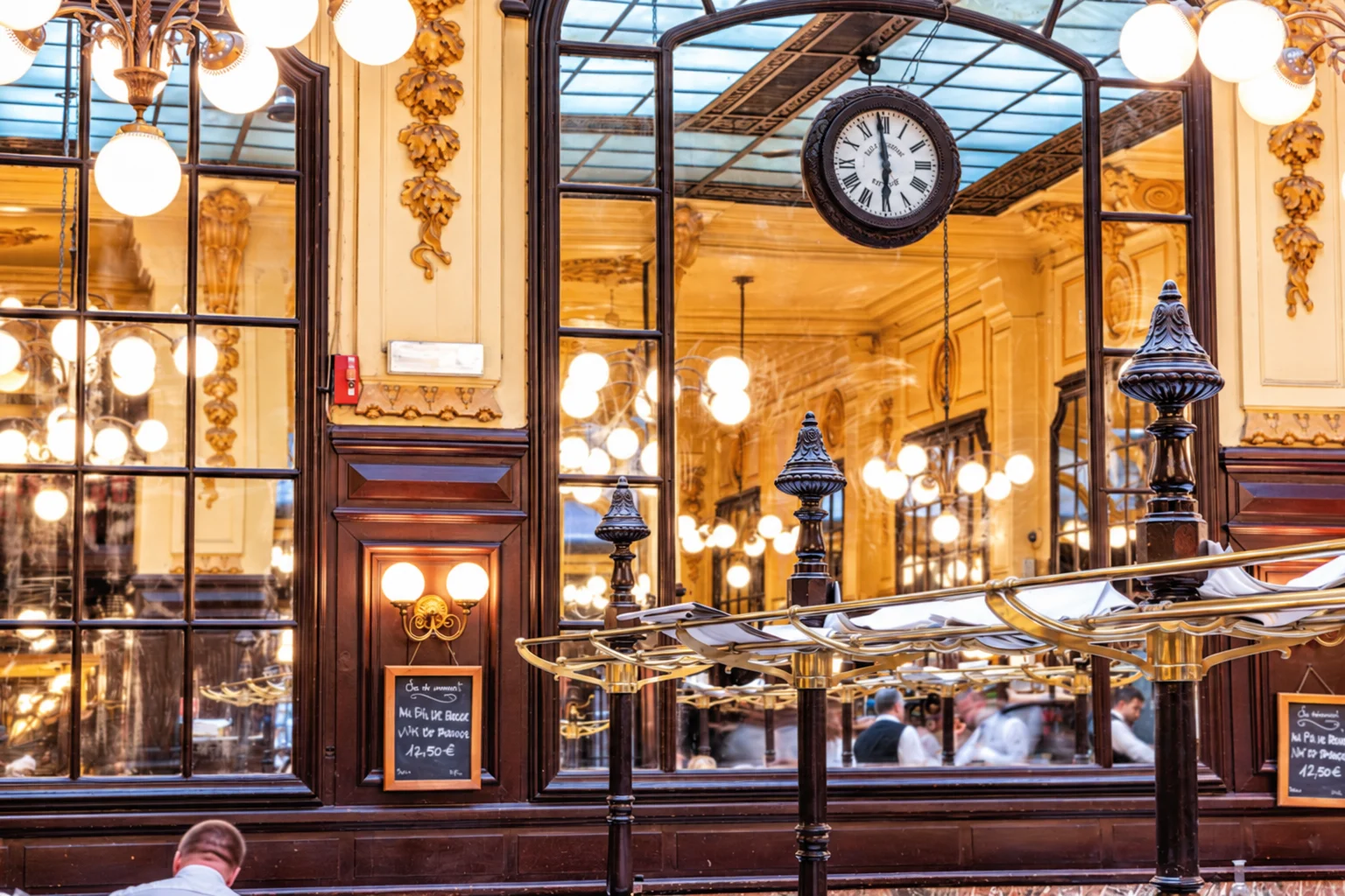 Часы, зеркала и латунные полки в зале Bouillon Chartier Grands Boulevards