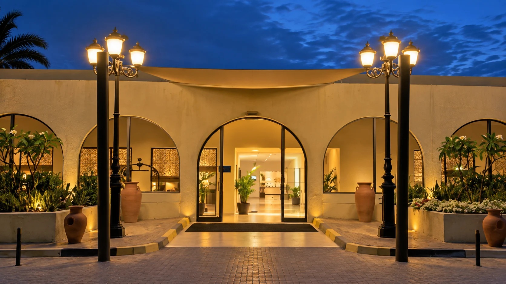 Арочный вход в Dhafra Beach Hotel при вечернем освещении