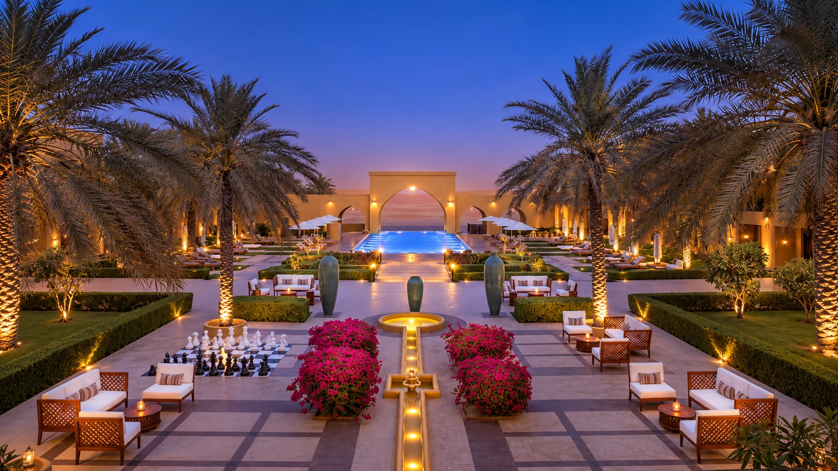 Вечерний двор Aldhafra Resort с пальмами и аркой у бассейна