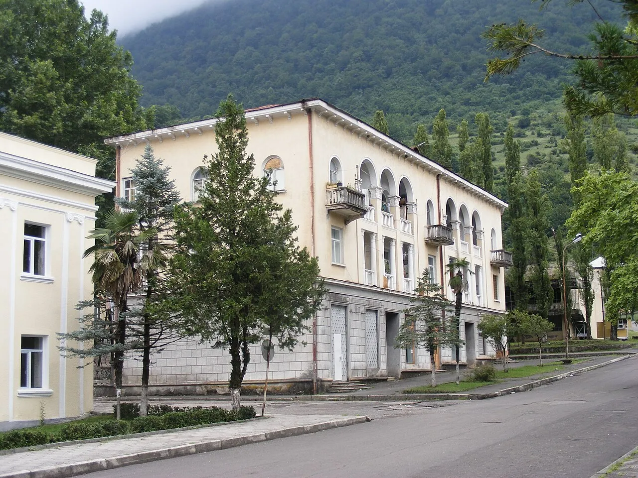 Здание с колоннами в Ткуарчале на фоне горы
